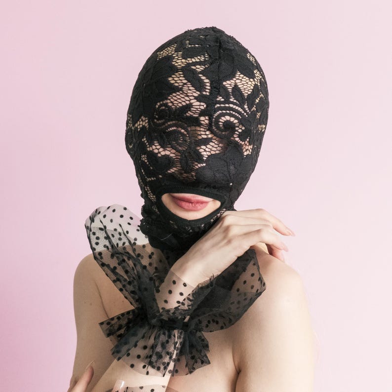 A handmade black full-face mask, only the mouth is visible. 67