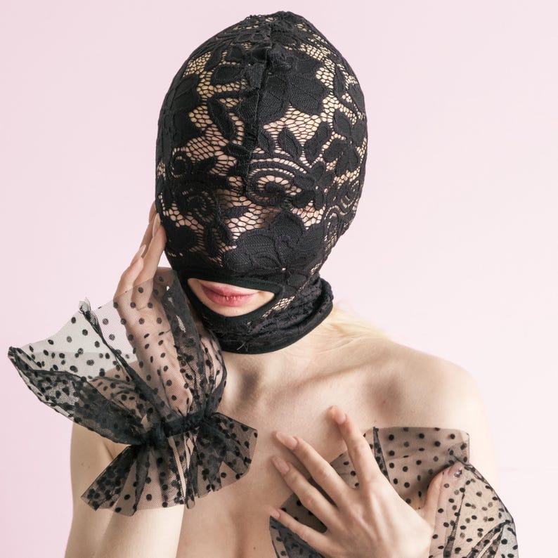 A handmade black full-face mask, only the mouth is visible. 67